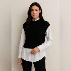 Calvin Klein black sweater vest layered over white long-sleeve button-down shirt